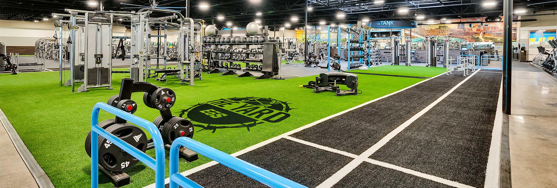 a large indoor shot of an eos branded box gym showing indoor turff and equipment