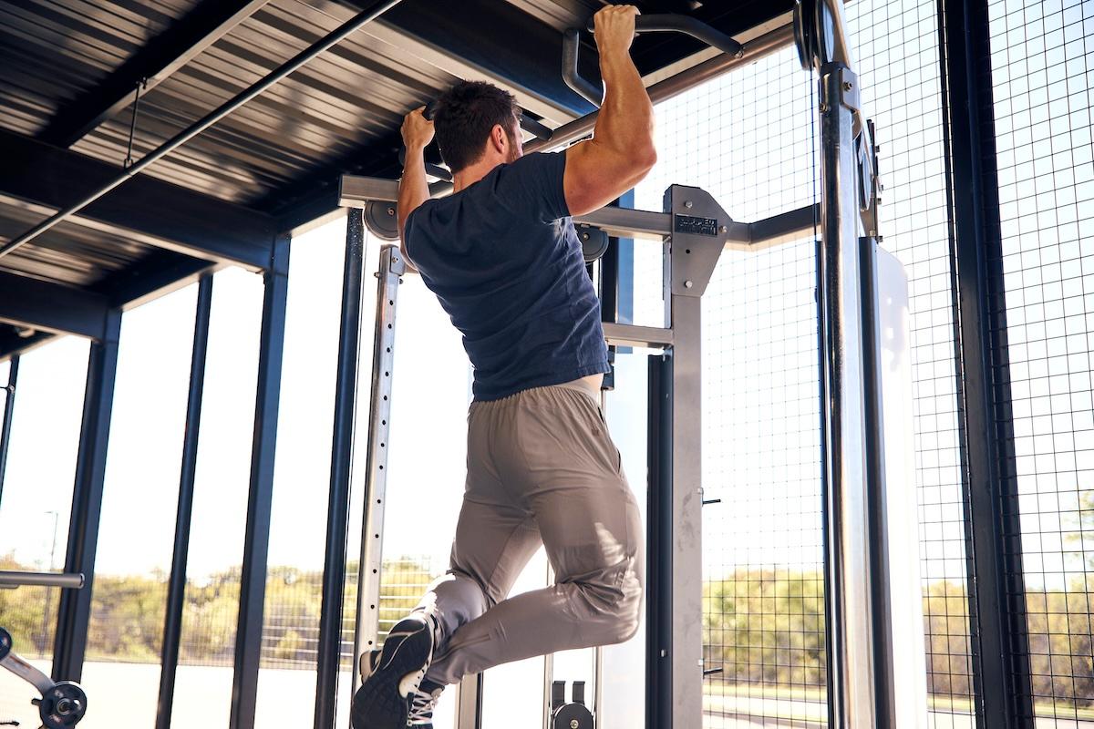 eos gym member doing pullups in the backyard