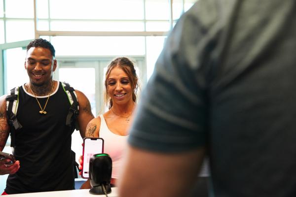 two eos gym members checking into the front desk