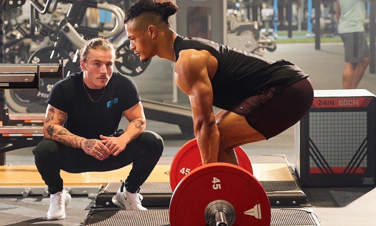 welcome workout hero with trainer helping eos gym member