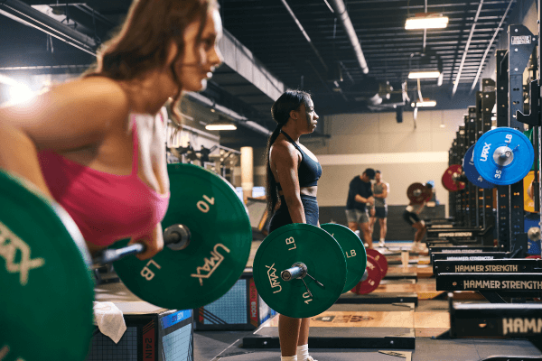 group of eos gym members doing barbell exercises on weight lifting platforms
