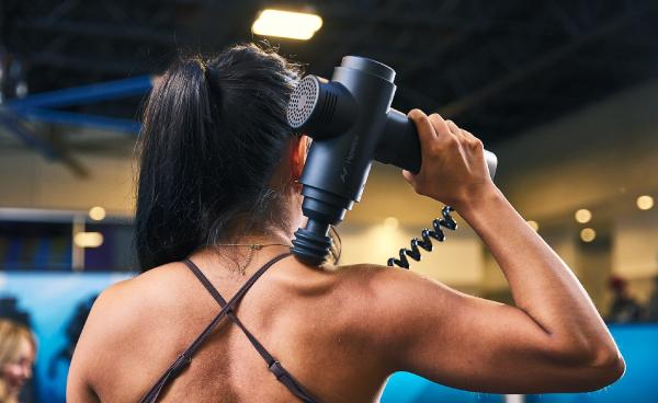 eos gym member using the massage guns in the tank