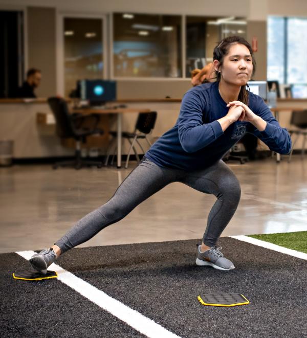 eos gym member doing dynamic isometrics on indoor turf