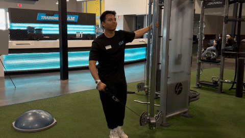eos fitness member doing cable lateral raises