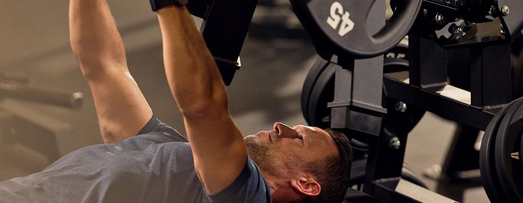 a will do gym member doing check press machine