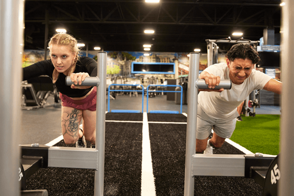 two eos fitness members training for hyrox sled push