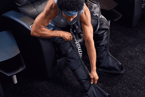 eos fitness member using compression boots for recovery