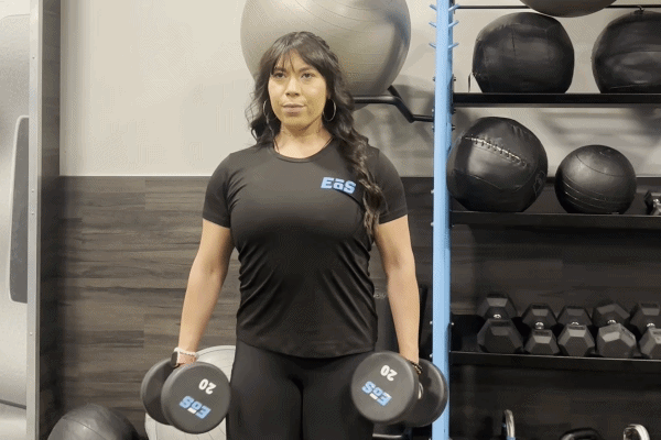 EōS Fitness member performing hammer curls in the gym.