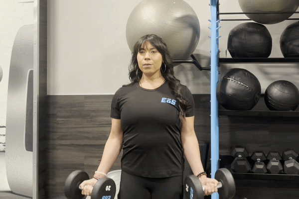 EōS Fitness member performing dumbbell curls in the gym.