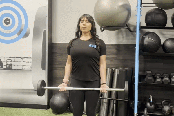 EōS Fitness member performing barbell curls in the gym.