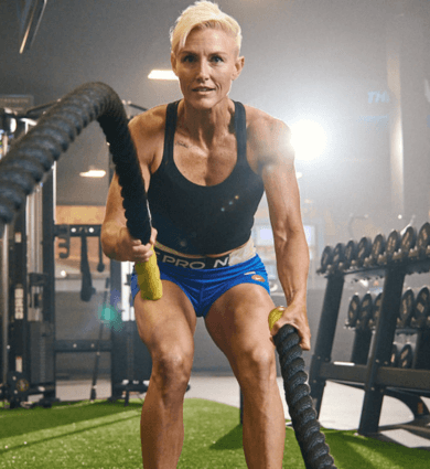 eos fitness female member working out with battle ropes